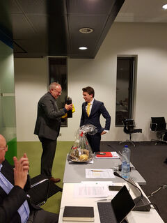 Jo van Ham ontvangt een fles wijn en bijpassende glazen tijdens zijn laatste optreden in de vergadering met de U-raad. Foto | Han Konings Jo van Ham ontvangt een fles wijn en bijpassende glazen tijdens zijn laatste optreden in de vergadering met de U-raad. Foto | Han Konings