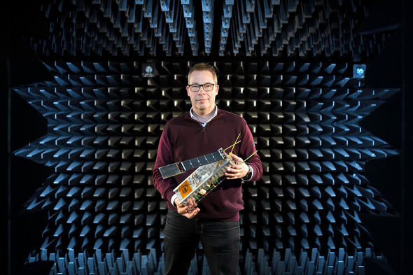 Mark Bentum in antennemeetkamer met een C3 nano-satelliet. Foto | Bart van Overbeeke Mark Bentum in antennemeetkamer met een C3 nano-satelliet. Foto | Bart van Overbeeke