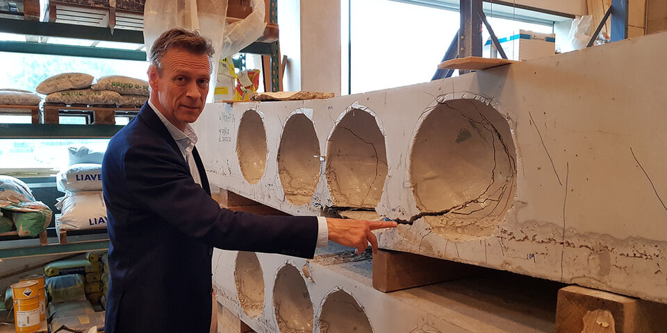 Simon Wijte in het lab van Bouwkunde bij een onderzochte proefplaat. Foto | Han Konings