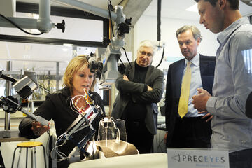 Minister Jet Bussemaker with the TU/e robot for eye surgery. Photo | Bart van Overbeeke